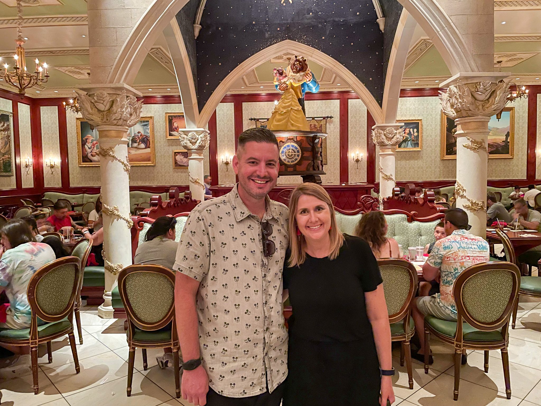 Couple standing in the grand ballroom at Be Our Guest Restaurant inside Magic Kingdom at Walt Disney World.