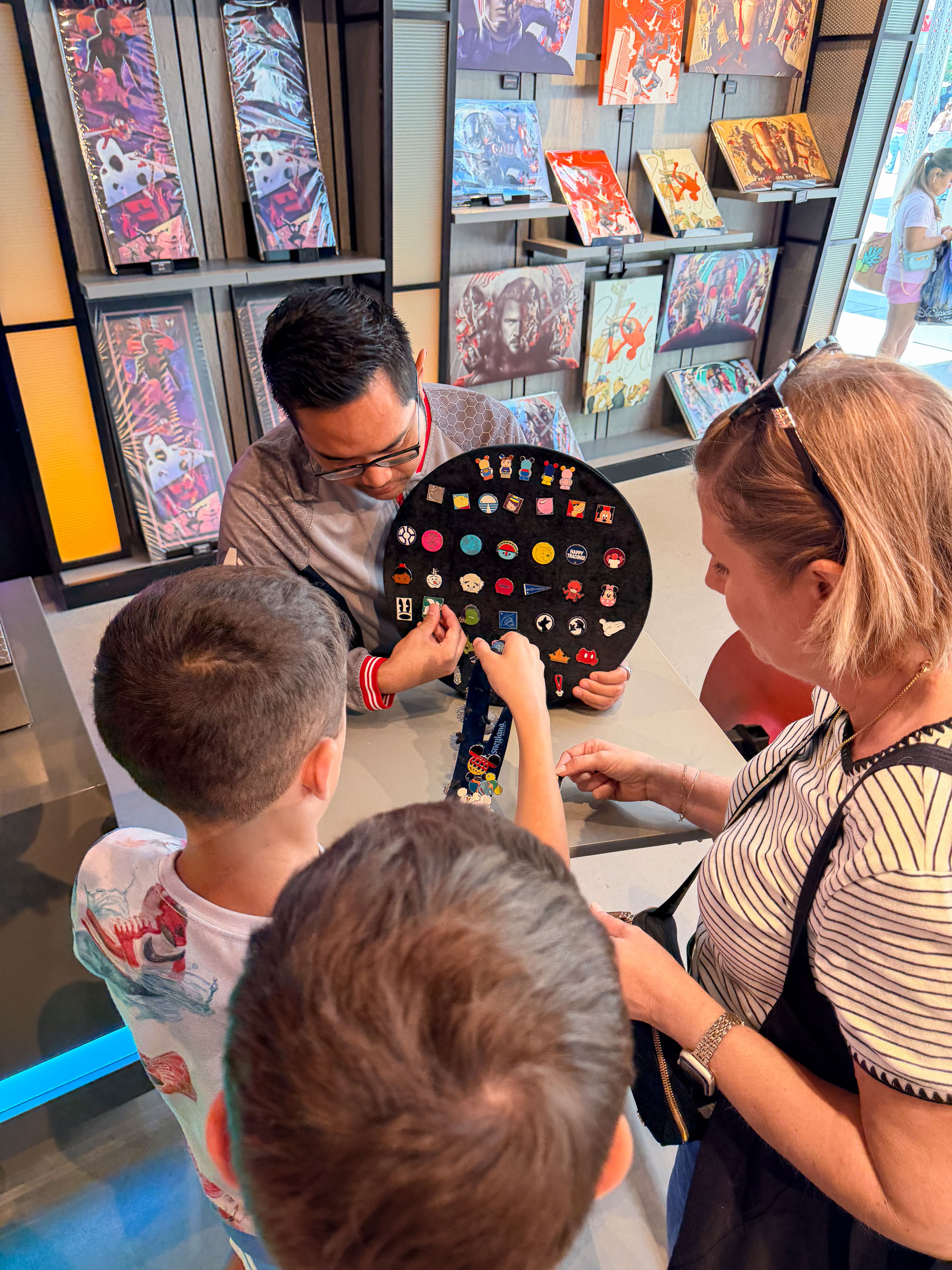 Cast member pin trading board covered in Disney pins, with kids trading