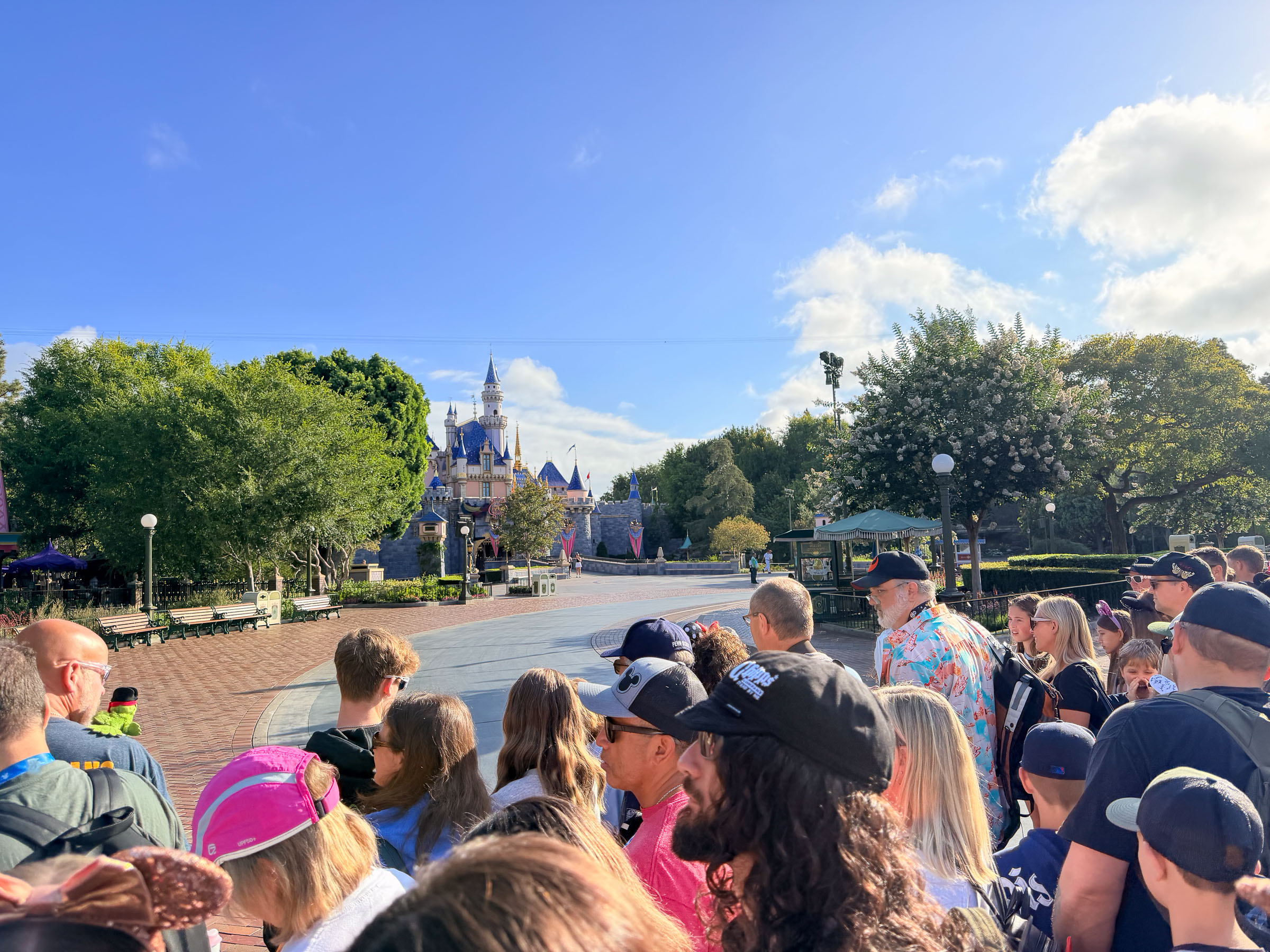 A morning rope drop crowd fills Main Street, U.S.A. at Disneyland, facing Sleeping Beauty Castle.