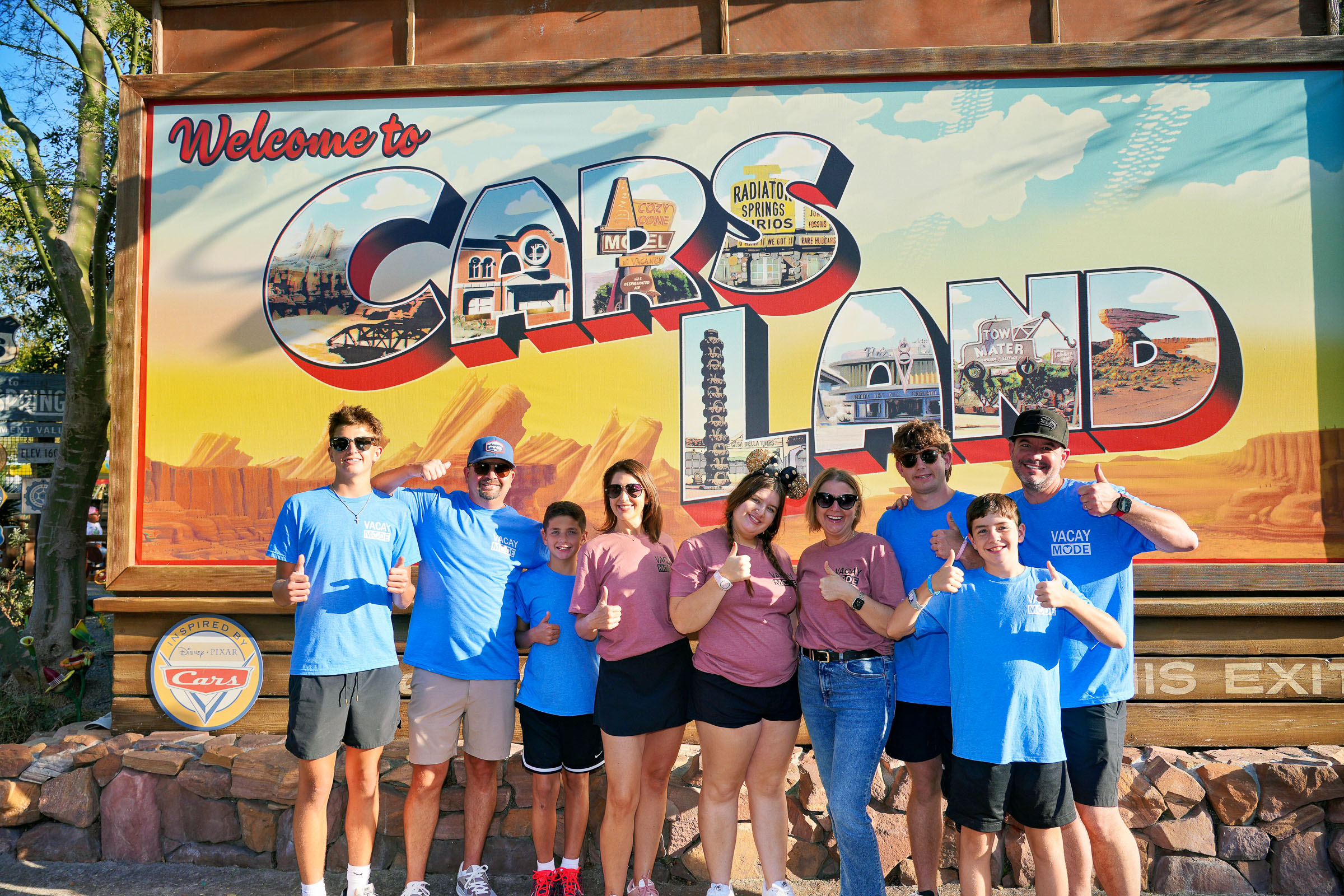 Crew in matching shirts at the Cars Land billboard