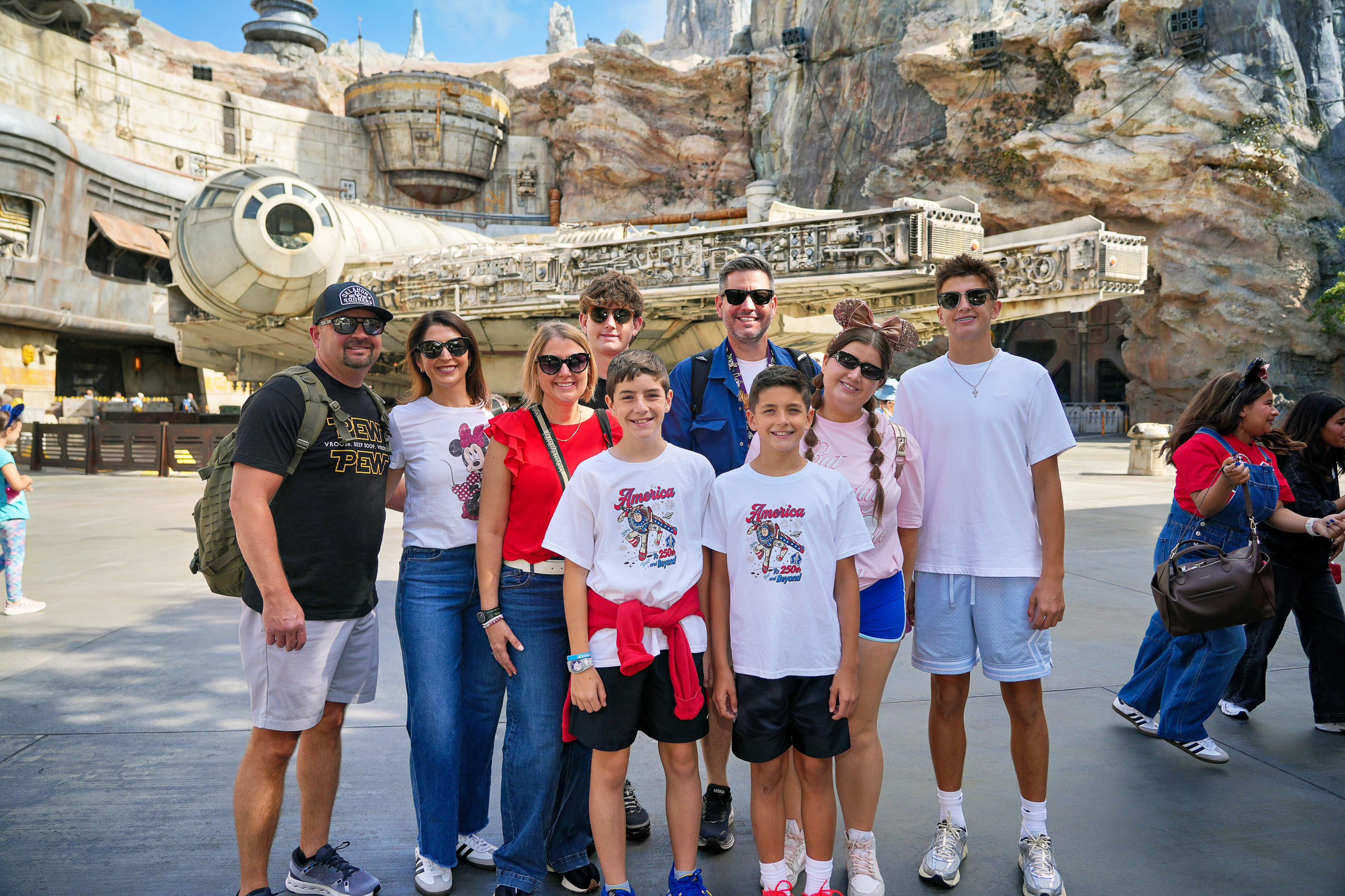 Family posing with the Millennium Falcon in Star Wars: Galaxy's Edge