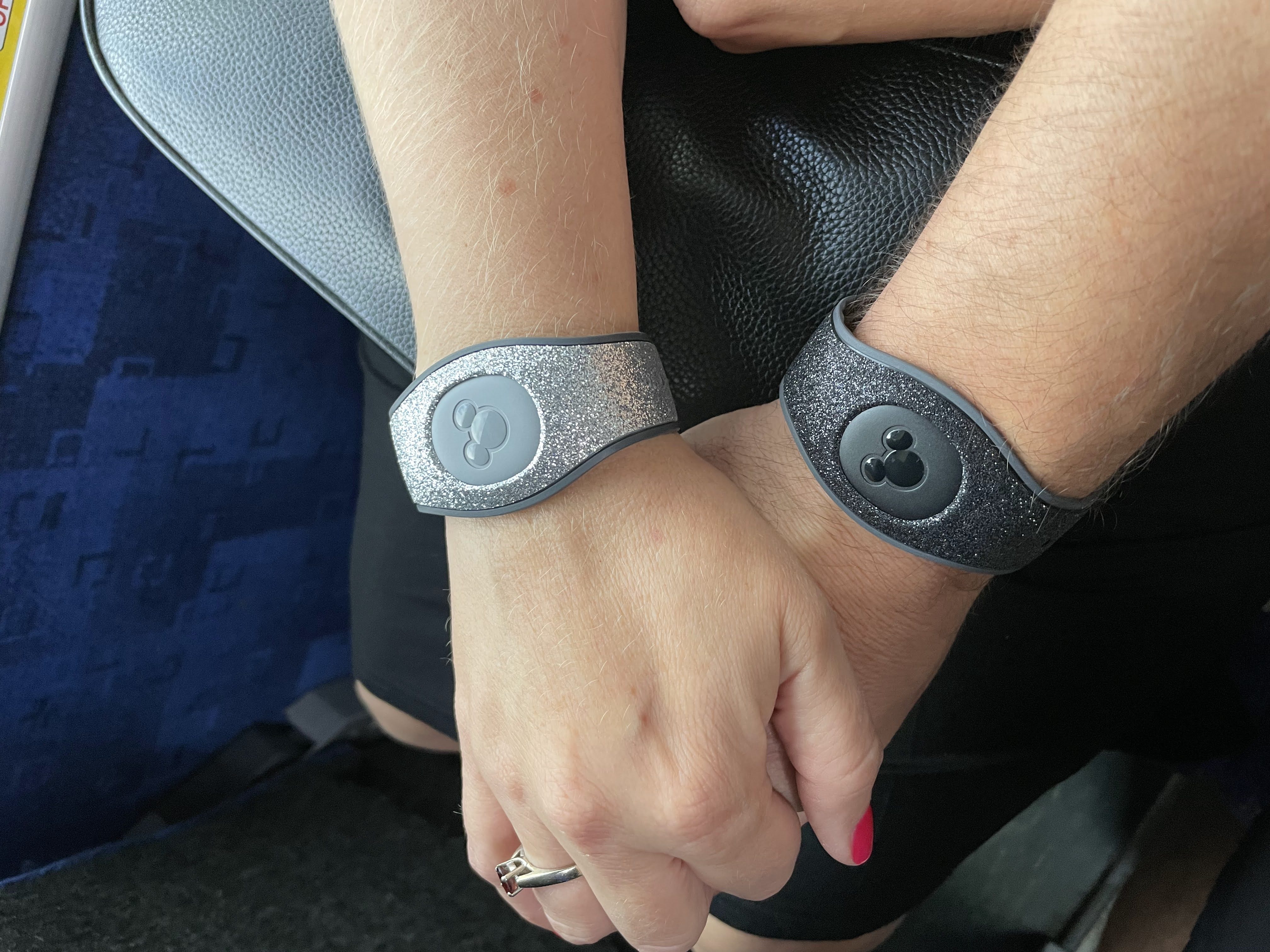 Two Disney MagicBands being worn on wrists — a perk that comes with staying at Disney Resort hotels.