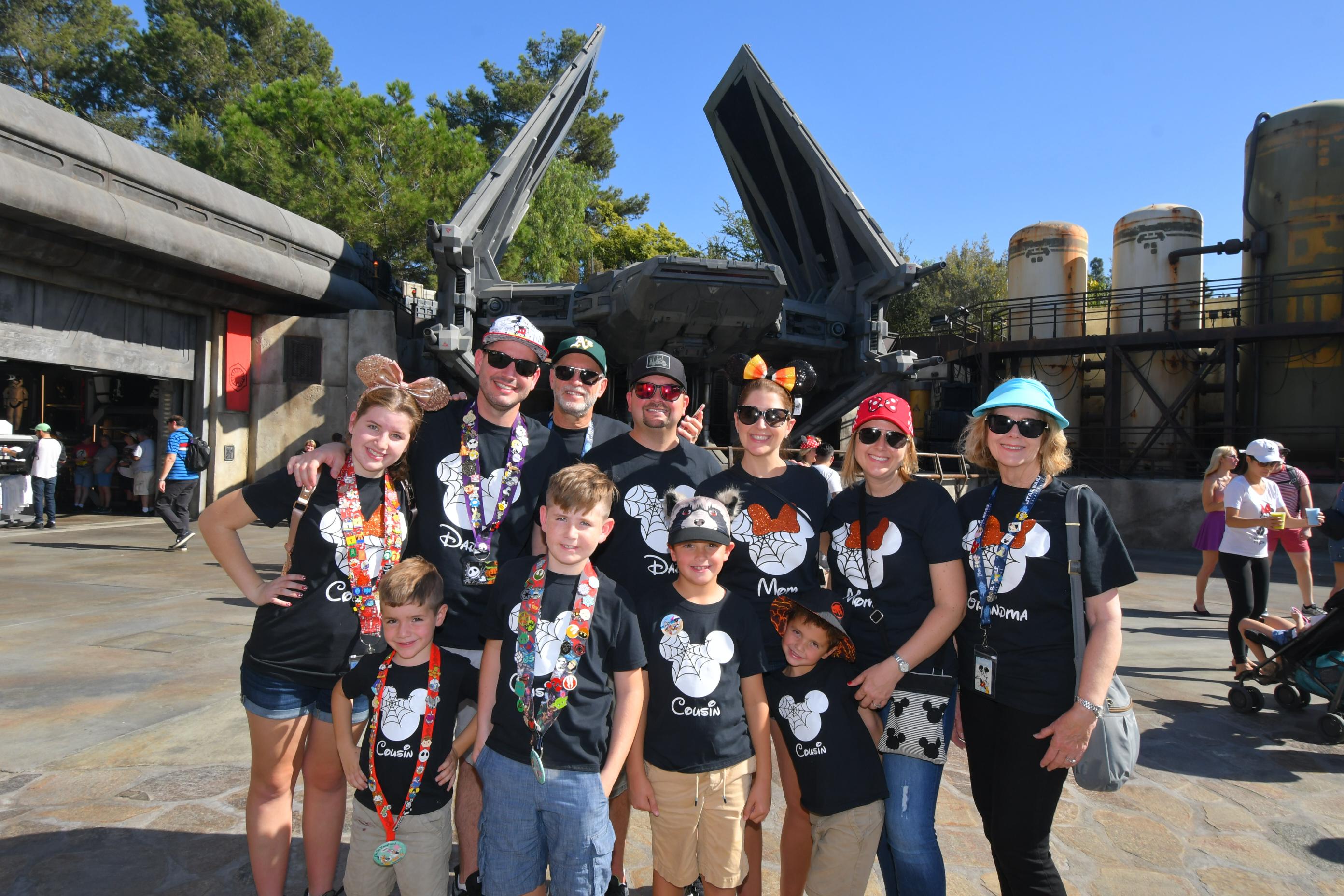 Family group posing in front of the Millennium Falcon in Star Wars: Galaxy's Edge at Disneyland.