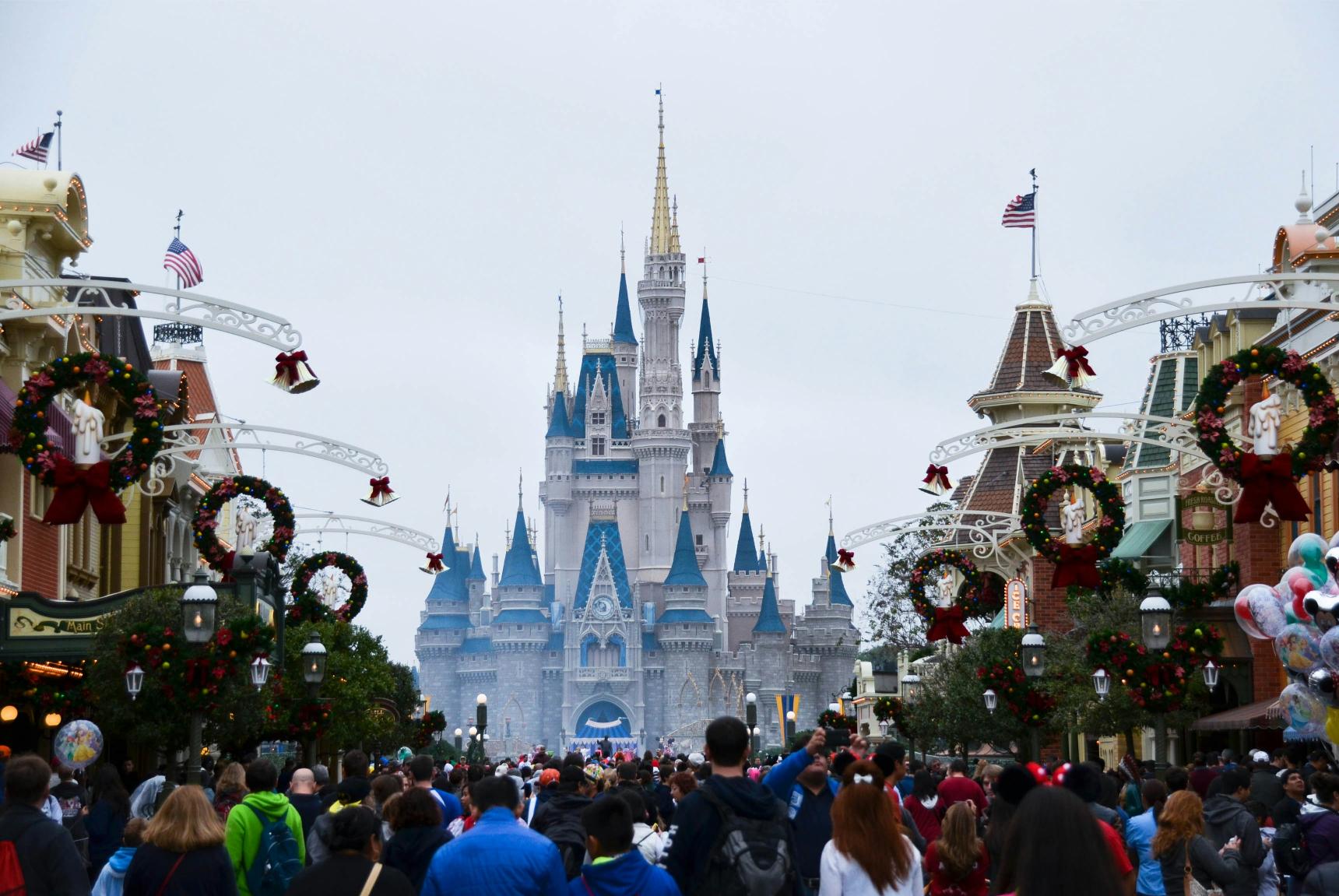 Magic Kingdom Main Street U.S.A. decorated for Christmas with holiday wreaths and lights leading to Cinderella Castle.